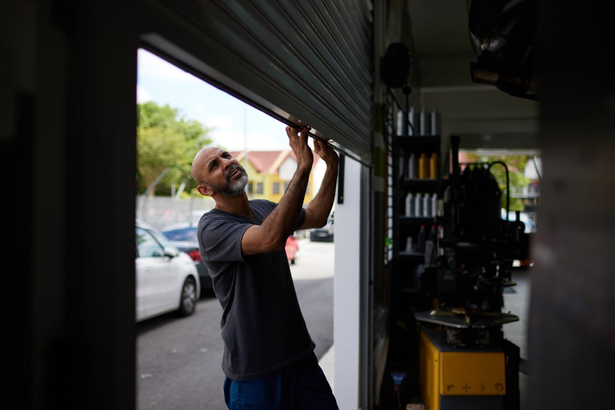 repair guy looking at garage door